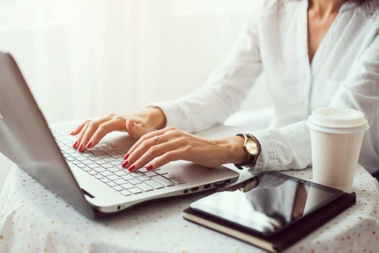 Woman working in home office hand on keyboard close up.